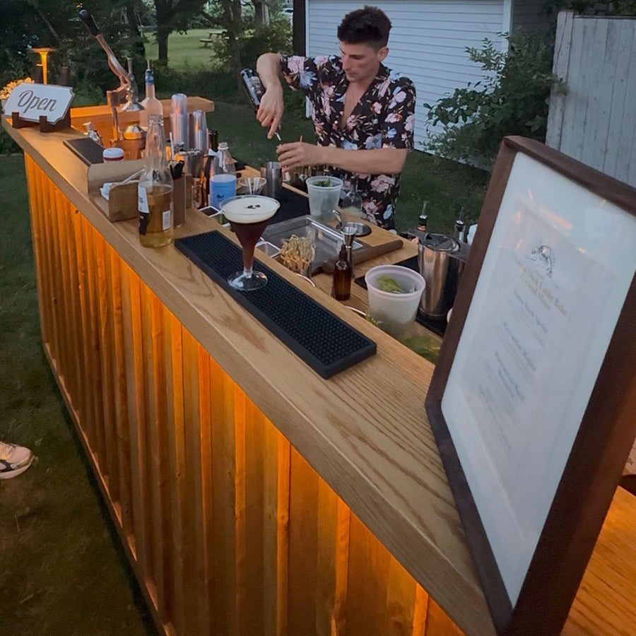 BZ bartender serving craft cocktails behind the red oak mobile bar with LED underlighting, mobile bar rental and dry hire bartending in Hull MA