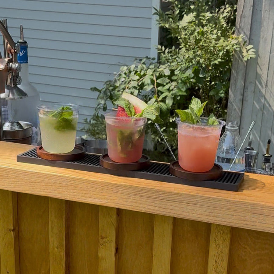 BZ three craft cocktails with fresh mint and fruit garnishes on a red oak bar top, mobile bar rental and dry hire bartending in Pembroke MA
