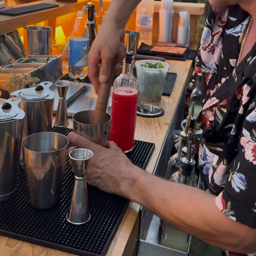 BZ TIPS certified bartender muddling a craft cocktail in a shaker tin behind the mobile bar, mobile bar rental and dry hire bartending in Milton MA